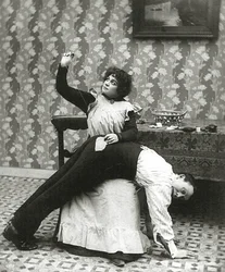 Frau näht einen Riss in einer Männerhose, um 1895
